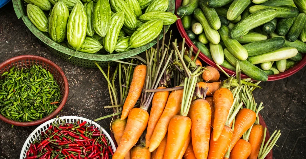 Colourful carrots, chillies and cucumbers in baskets