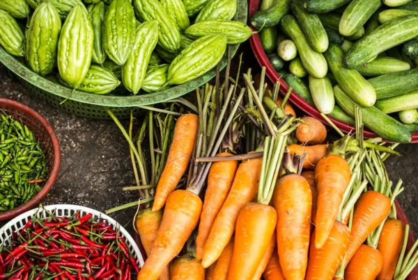 Colourful carrots, chillies and cucumbers in baskets