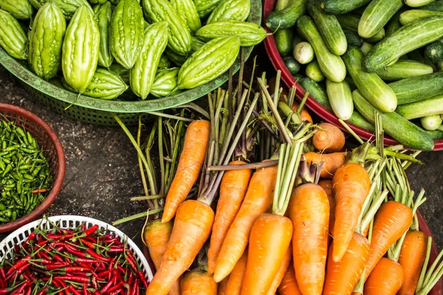 Colourful carrots, chillies and cucumbers in baskets